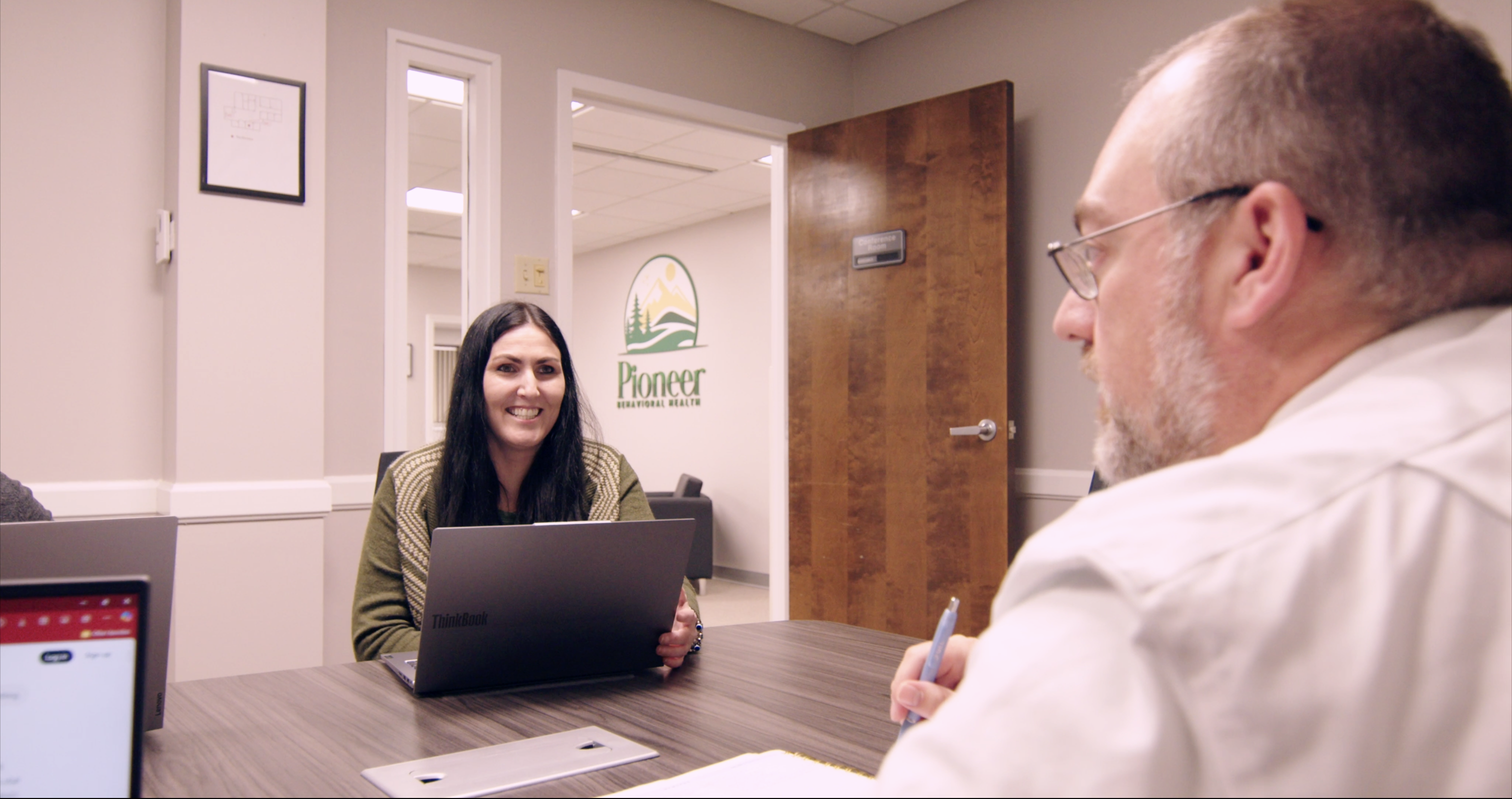 Women and man sitting at a table at Pioneer Behavioral Health.