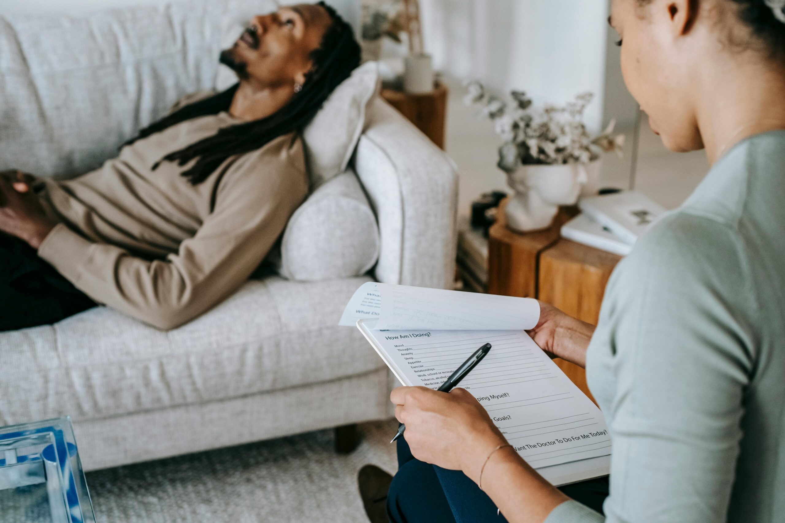 A man laying on the couch in front of his therapist.