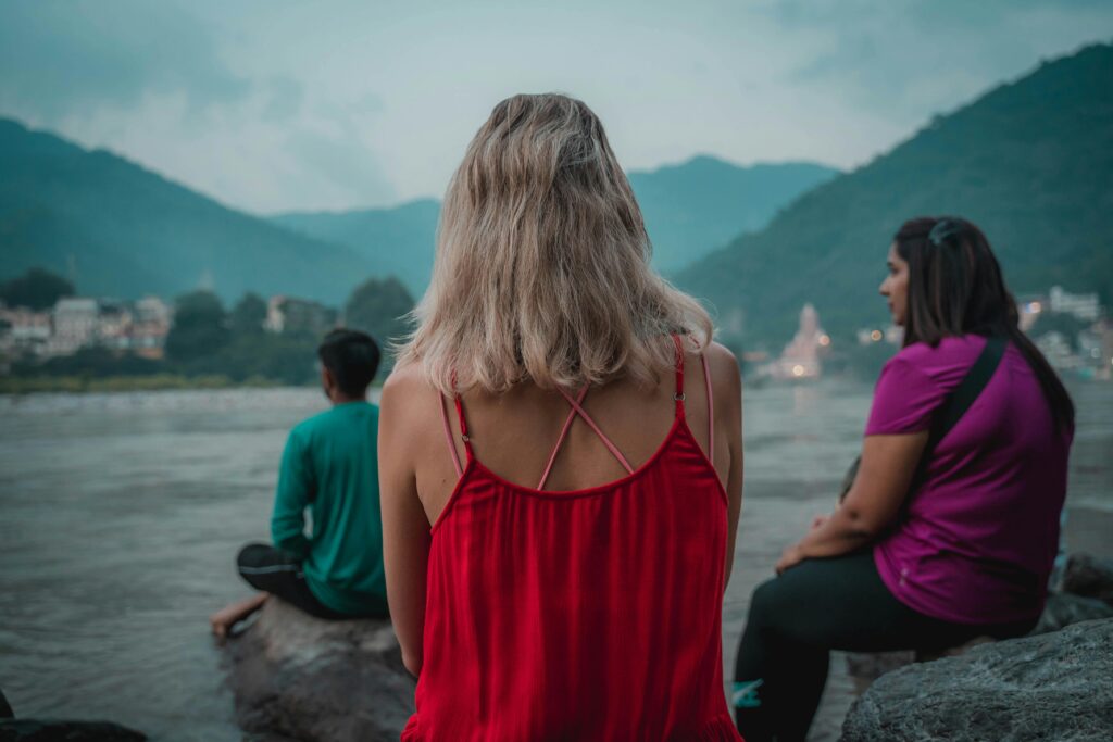 Three people overlooking the ocean.