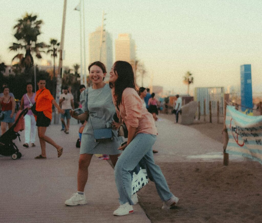 Two friends walking on the beach boardwalk.