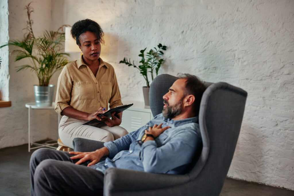 A man in a therapy session learning how to manager his obsessive-compulsive disorder (OCD) naturally.