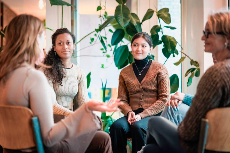 A group of adults in a group therapy session, an important part of the recovery process.